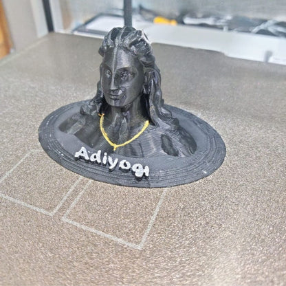 3D-printed figurine  'Adiyogi' text on a gray surface