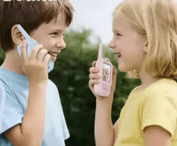 Two children playing with toy phones outdoors